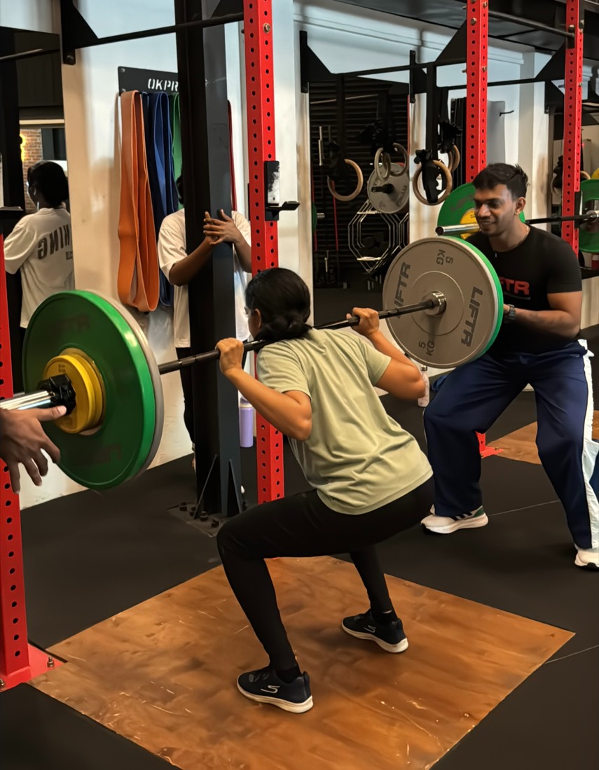 A LIFTR coach spotting a member’s back squat