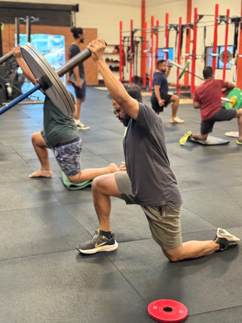 A batch doing weighted reverse lunges in a coached session