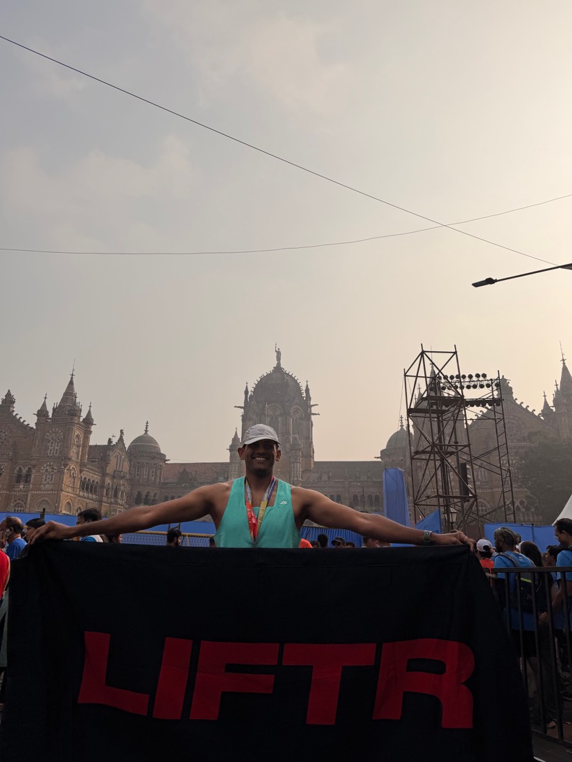 Anish at the Mumbai Marathon finish, holding a LIFTR banner