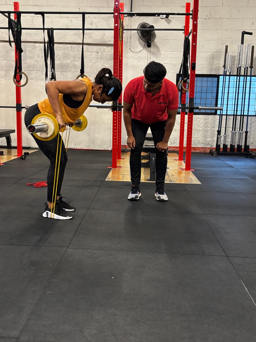 A LIFTR coach correcting a member’s row