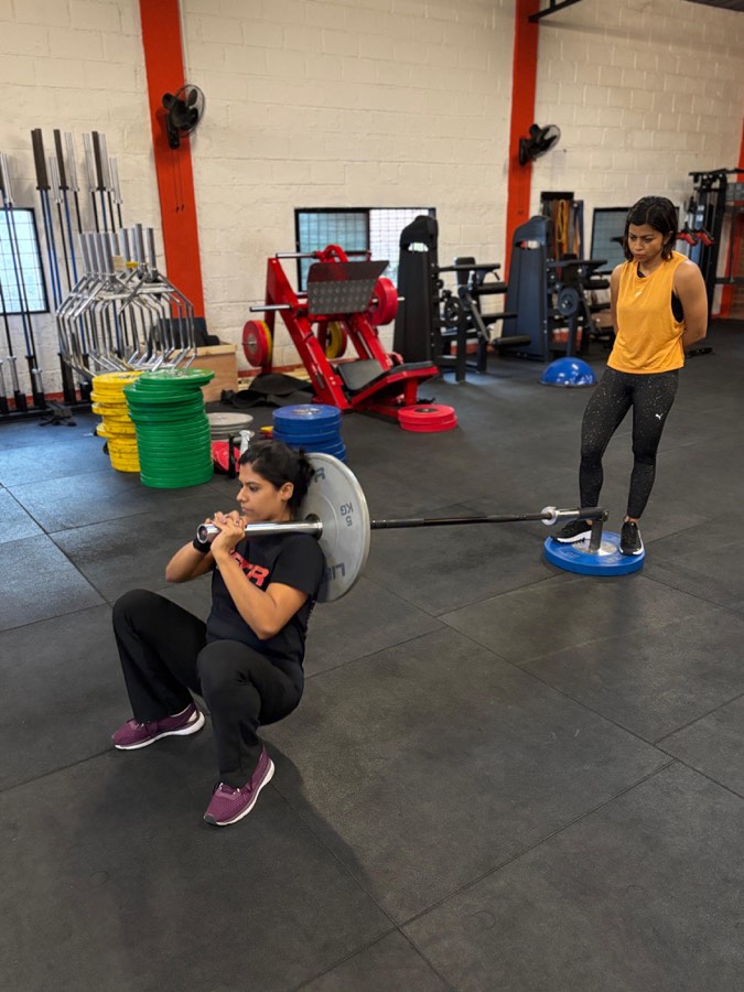 A LIFTR coach watching a member’s landmine squat